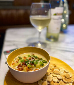 Bowl of Razor Clam Chowder, Crackers, and Wine
