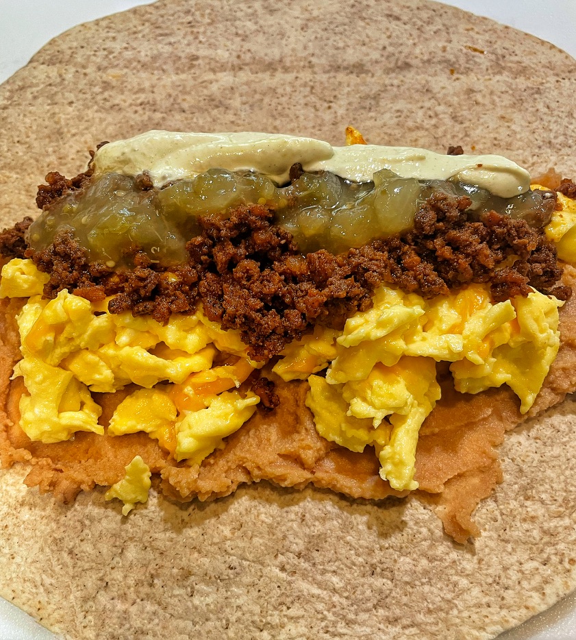 Adding Salsa and Crema to Breakfast Burrito